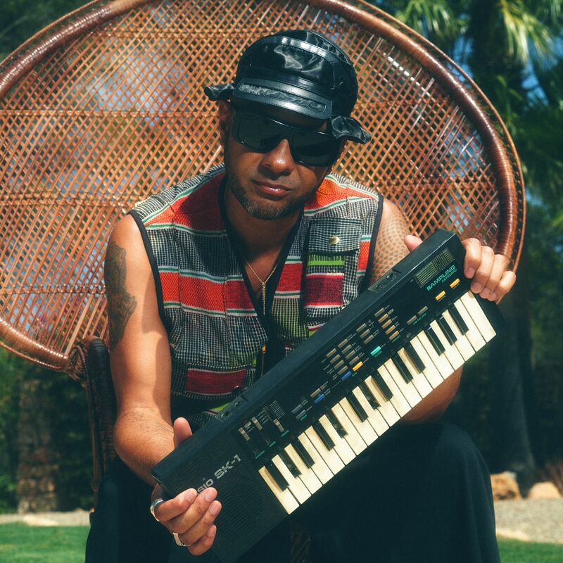 A man with sunglasses holding a keyboard