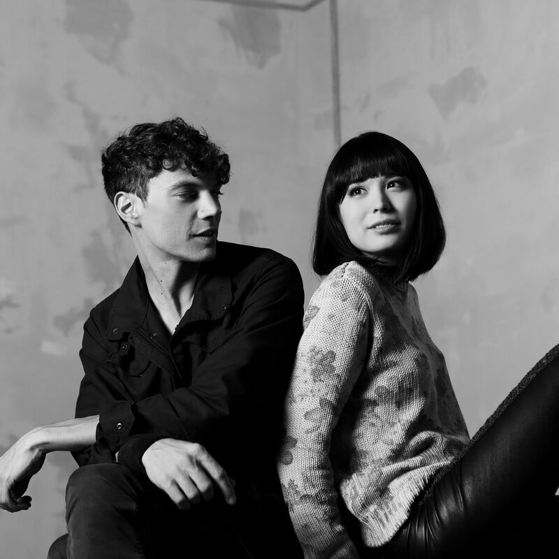 Pianists Alice Sara Ott & Francesco Tristano sitting on a piano stool