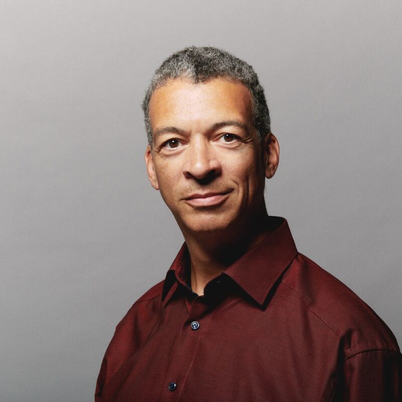 Baritone Roderick Williams looking straight at the camera, in a red collared shirt