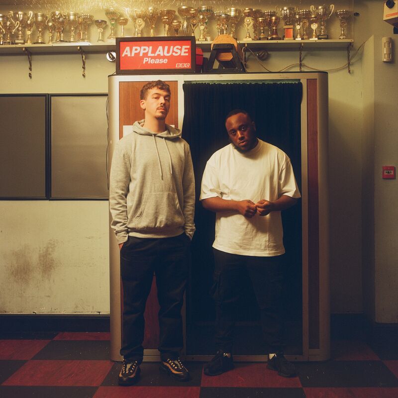 Two men posing by a photobooth