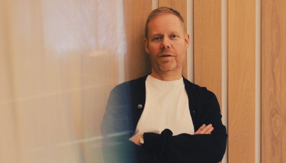 A man leaning against a wall with his arms folded