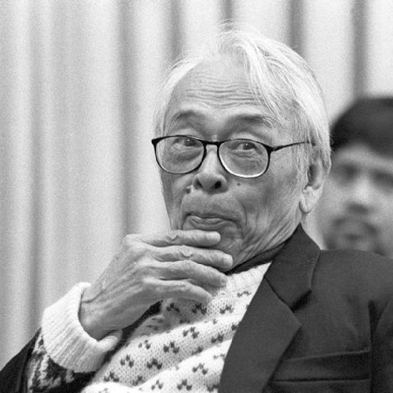 Composer José Maceda wears black framed glasses with his hand on his chin