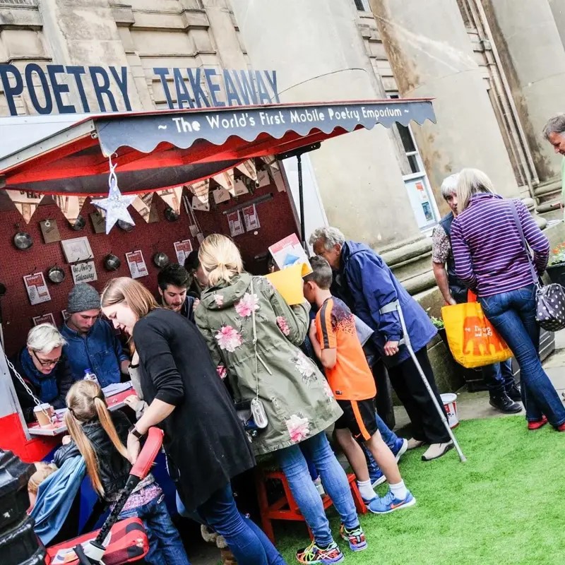 a group of people standing around the Poetry Takeover stall