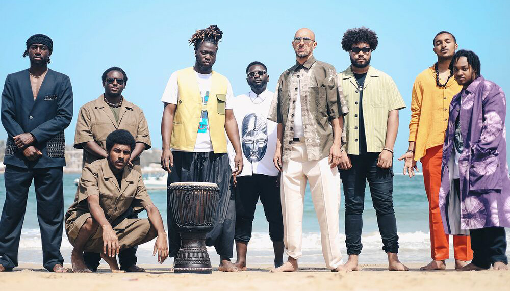 Members of the Balimaya Project standing on a beach with the ocean and blue skies behind them