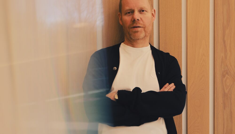 A man leaning against a wall with his arms folded