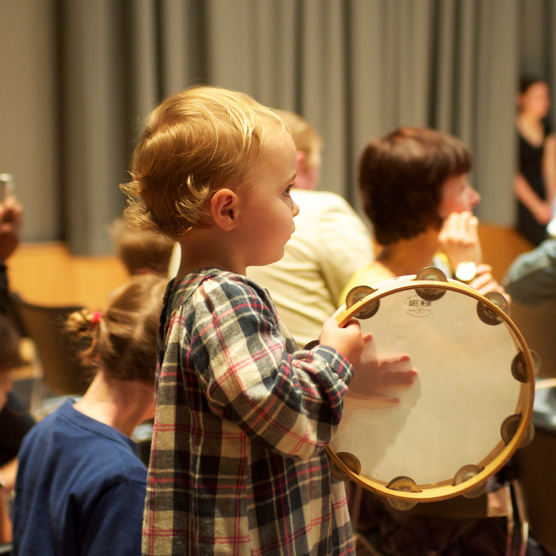 Child playing with a tambourine