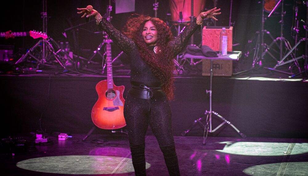 Chaka Khan stands on the Royal Festival Hall stage with her arms lifted