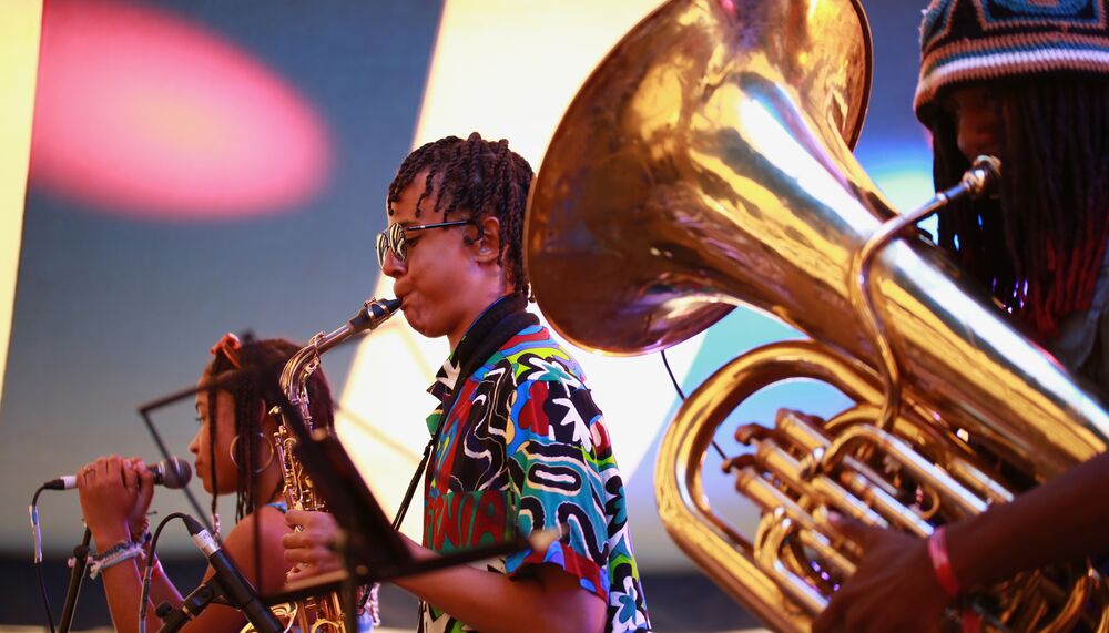 Three young jazz musicians playing the tuba, saxophone and singing as part of Tomorrow's Warriors