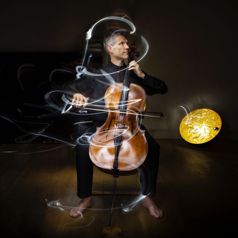 Matthew Barley playing the cello with light graphics