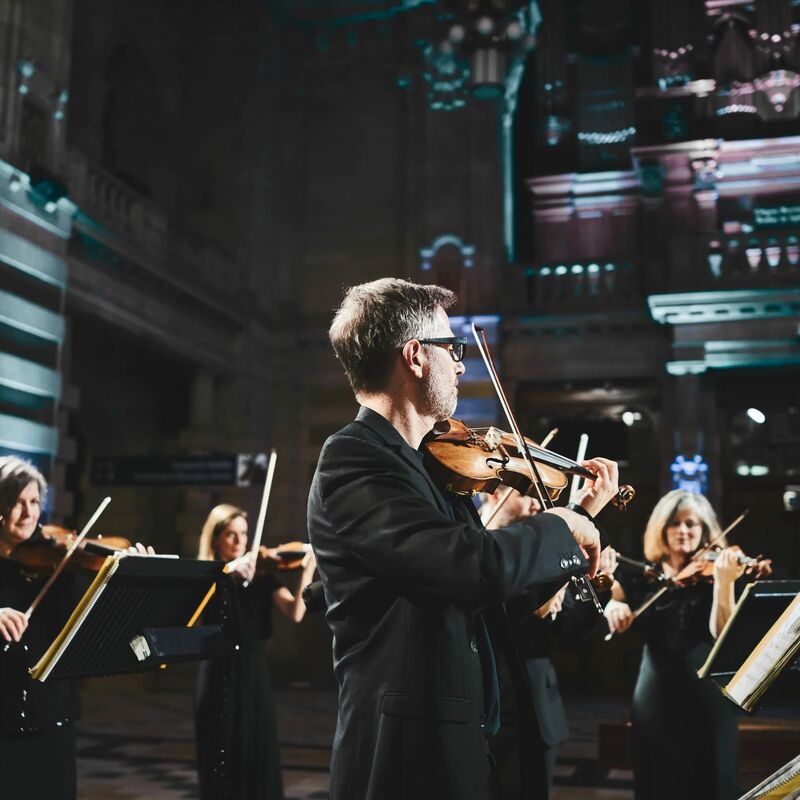 Scottish Ensemble playing violins in an ornate concert venue