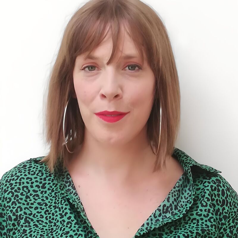 Jess Phillips wears a green shirt and silver earrings