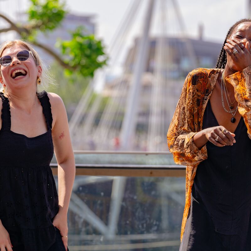 Two women laughing on the Riverside Terrace