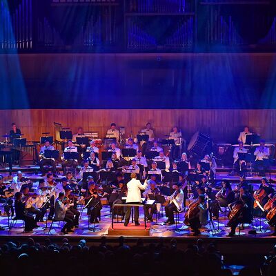 Orchestra onstage with blue lighting