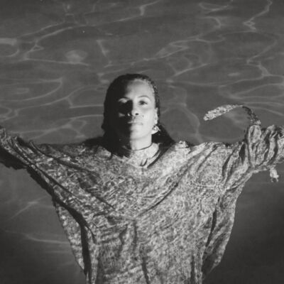 Neneh Cherry floating in a swimming pool