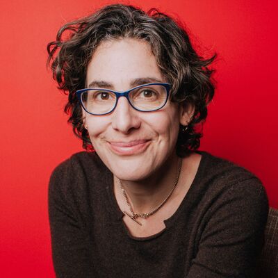 Sarah Koenig, journalist and presenter, a portrait of a person in a brown top with a red background.