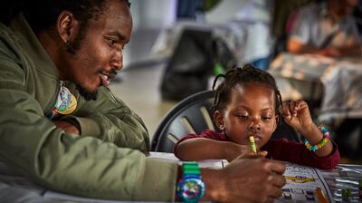 A father and a child colour together