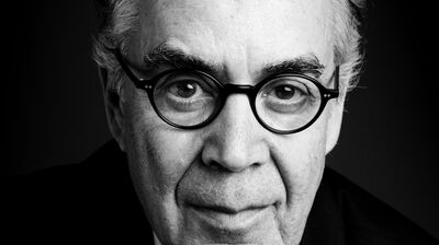 A black and white portrait of Howard Shore, who is wearing round glasses and a suit