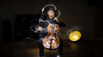 Matthew Barley playing the cello with light graphics