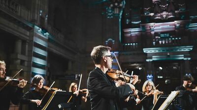 Scottish Ensemble playing violins in an ornate concert venue