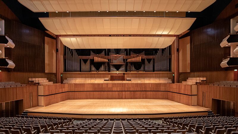 Royal Festival Hall auditorium with rows of seats sloping down to a large wooden stage