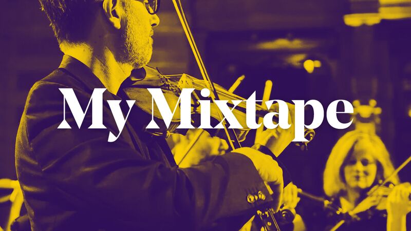 Scottish Ensemble playing violins with one person in the centre of the group in a large concert venue. Over the top of the violinists are the words 'My Mixtape' in white text.