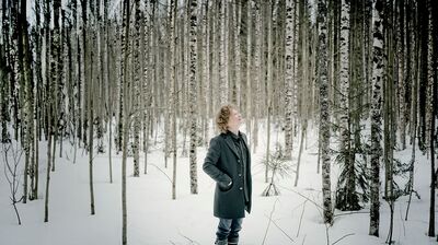 Santtu-Matias Rouvali standing in front of a lake and forest in Finland