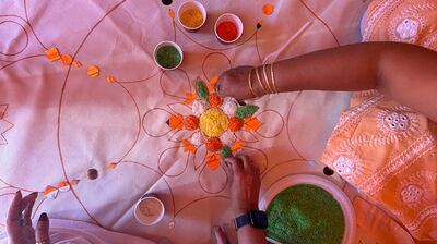 a birds eye view of participants helping to create a communal artwork using vibrant colours