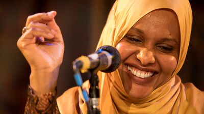 Asha Lul Mohamud Yusuf standing at a microphone, clicking her fingers.