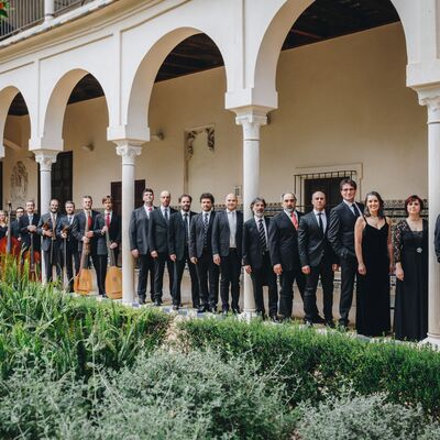 Concerto Italiano ensemble standing in line next to a white building with Islamic architectural features