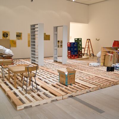 Installation view of Haegue Yang Storage Piece with wooden pallets, and furniture in a large room