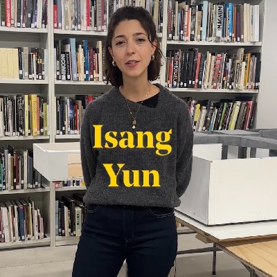 A woman standing with a bookshelf behind her, with the name Isang Yun in text over her body.