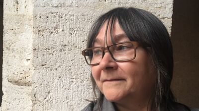 Ali Smith in glasses looking to the side