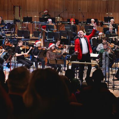 Orchestra onstage dressed in christmas festival outfits