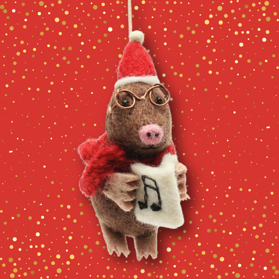 A sweet wool felt mole decoration, wearing a christmas hat, spectacles and red scarf, holding a music book.