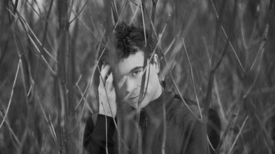 Paul Lewis standing among naked branches in a snowy setting