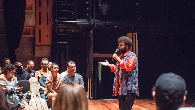 Artist on stage speaks to a captivated audience