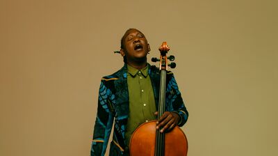 Celloist Abel Selaocoe singing while holding his cello