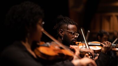 A Chineke violinist plays his instrument intently