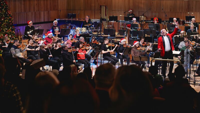 Orchestra onstage dressed in christmas festival outfits