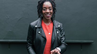 Athena Kugblenu wearing a black leather jacket over an orange top