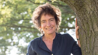 Jeanette Winterson standing by a tree.