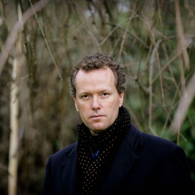 Edward St Aubyn wearing a coat outdoors.