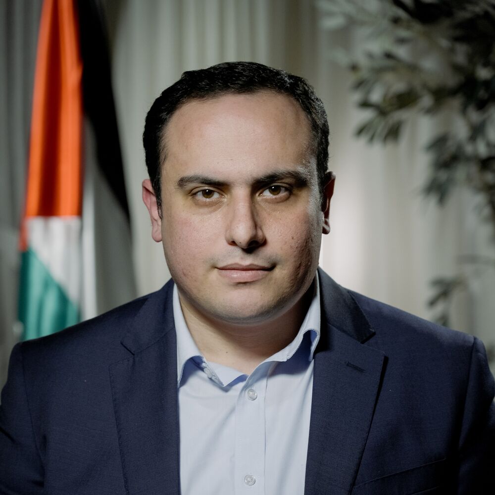 Ahmed Alnaouq wearing a navy blazer and blue shirt.