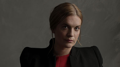Vocalist Ruby Hughes looking at the camera wearing a black blazer and red top