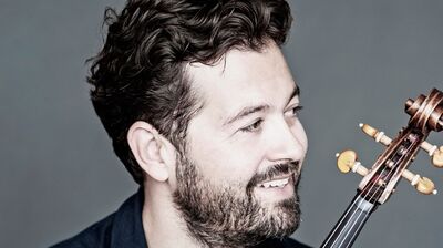 Violist Lawrence Power holding his viola and smiling