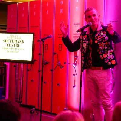 Speaker standing on NPL stage in front of a microphone.