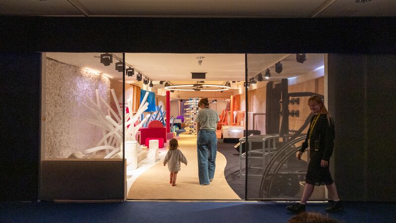Parent and child walking through the entrance to the Replay recycled play space.