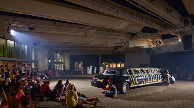 A limousine with gratiffi on and a crown watching