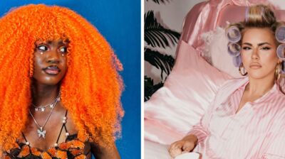 Two women looking at each other one with bright and big ginger curly hair and the other with hair coils in.