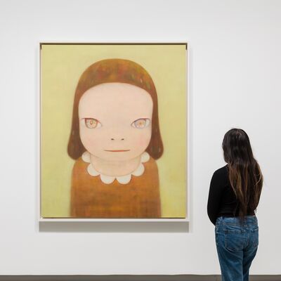 A person seen from the back as they look at a Nara artwork